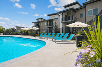 Pool deck with bright blue lounge chairs and umbrellas